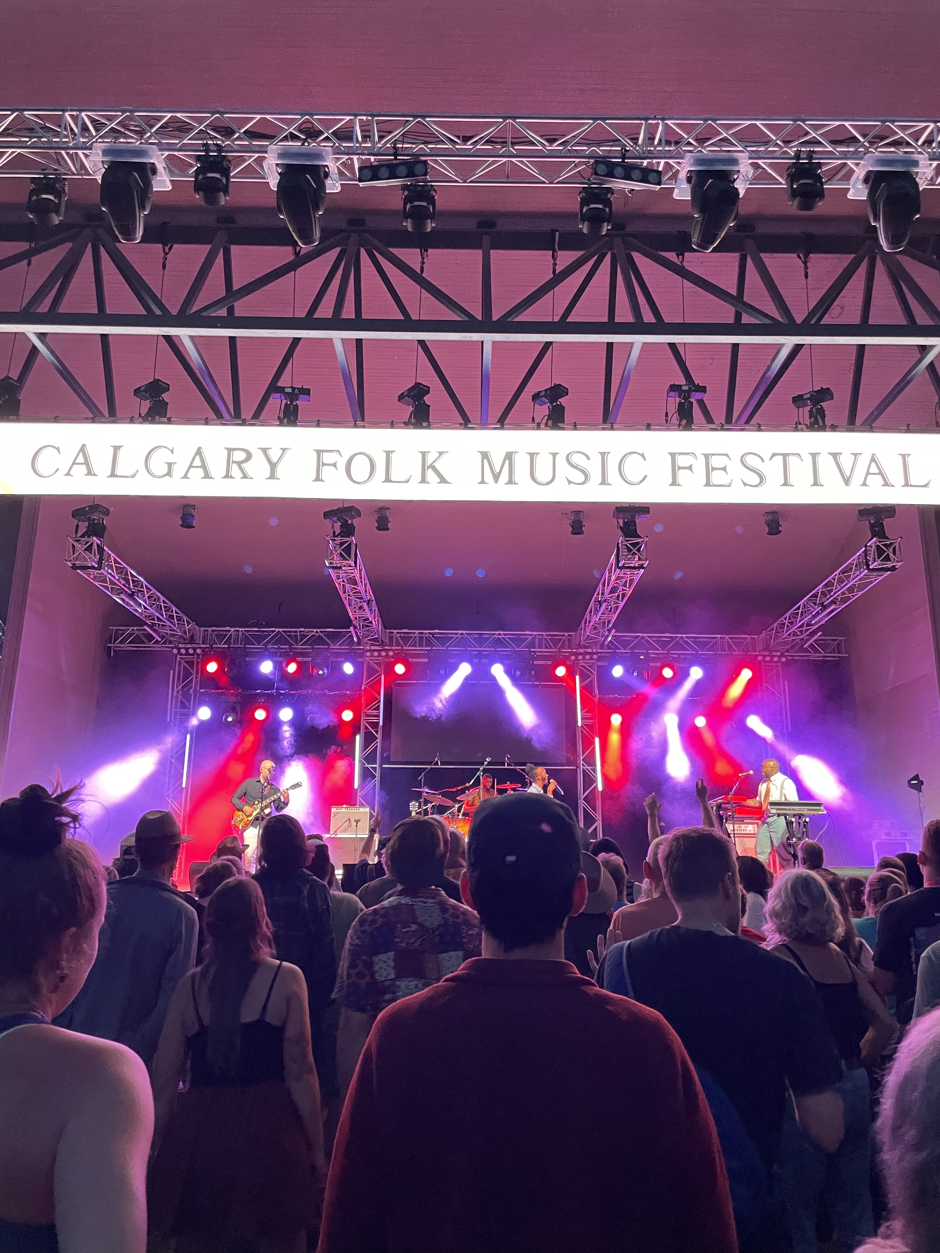 A crowd at an outdoor music festival watching the main stage