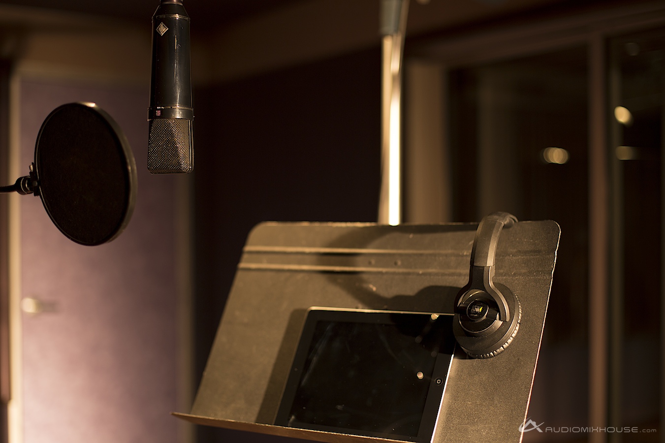 Recording studio microphone, headphones, and digital sheet music on a stand
